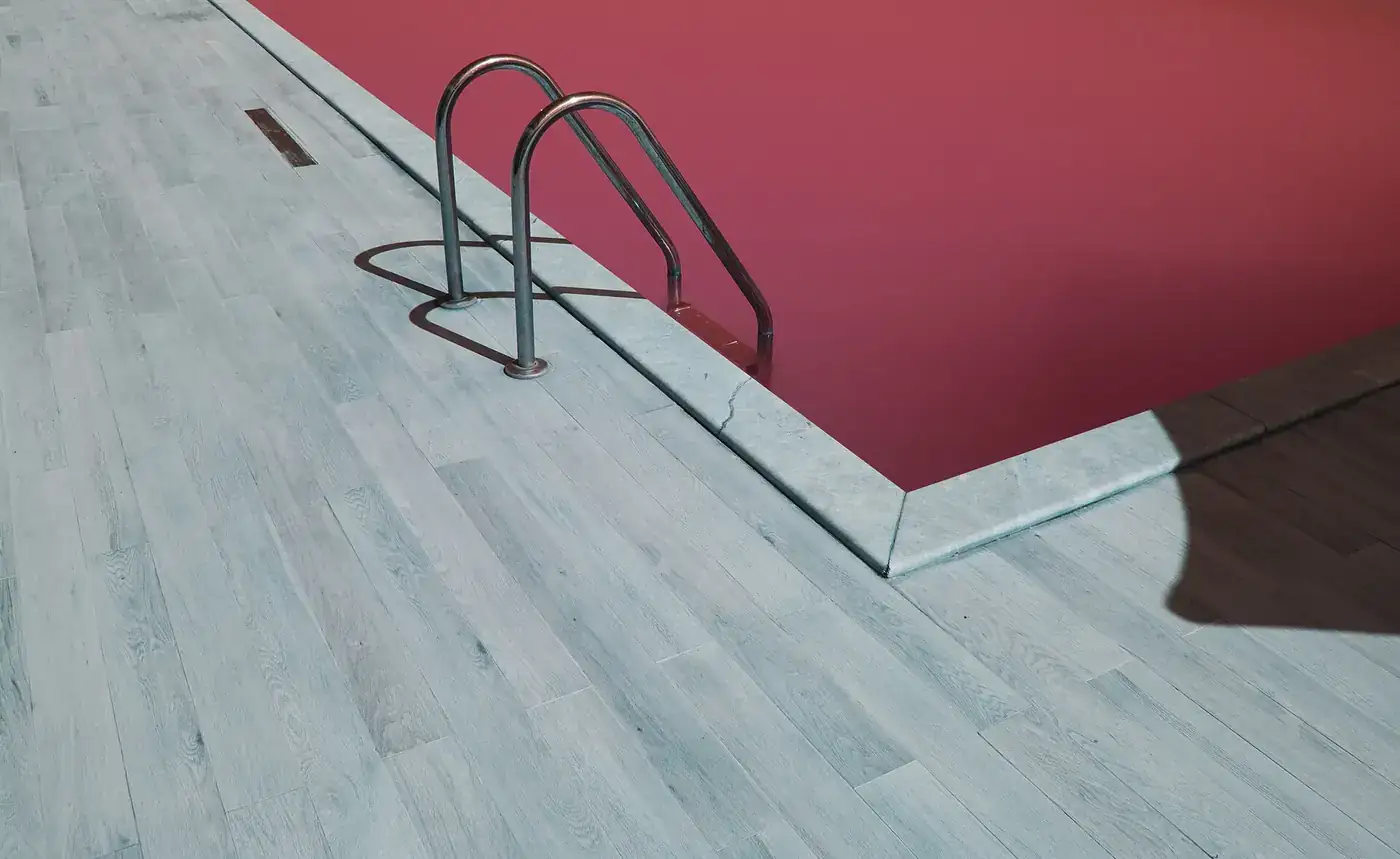Bordo de uma piscina de competição com escada de acesso à água, sem nadadores.