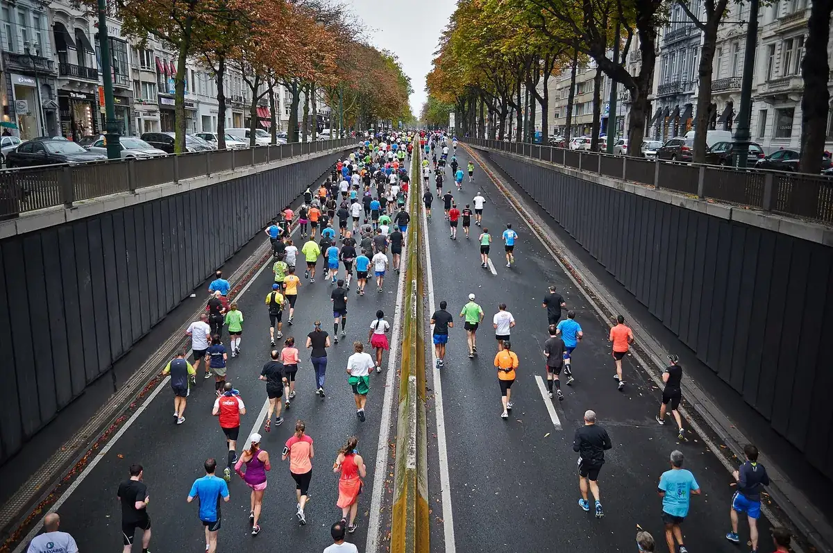 Triatleta a correr num percurso urbano vedado, visto de perfil.