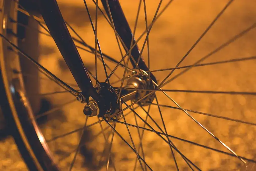 Pormenor da roda e da transmissão de uma bicicleta de estrada parada sobre alcatrão.